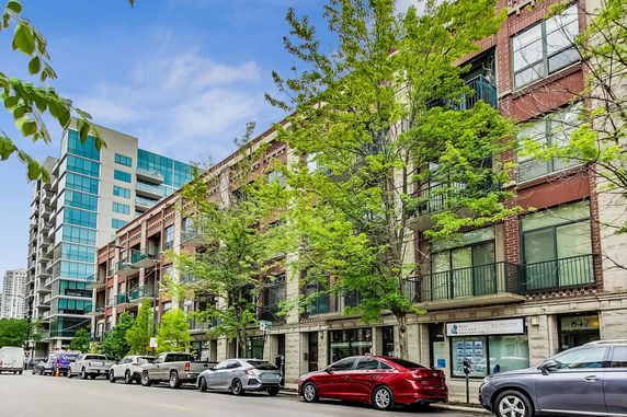 Street view of multi-story residential buildings with balconies.