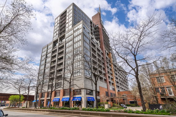 Front view of a modern multi-story building with large windows and balconies.