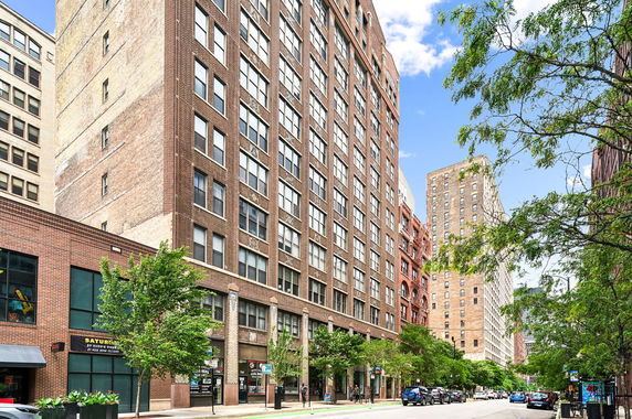 Front view of a multi-story brick building on a city street.