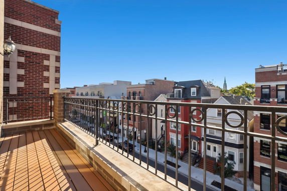 Balcony view showing a street lined with various residential buildings.