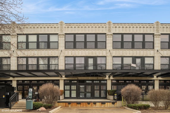 Front view of a multi-story building with large windows and ornamental design.