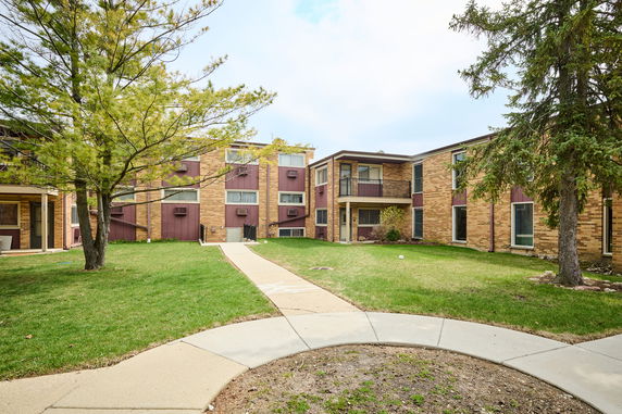 Front view of a multi-story apartment building with brick exterior and balconies.