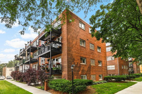 Front view of a brick apartment building with balconies.