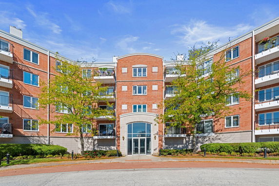 Front view of a red brick multi-story apartment building.