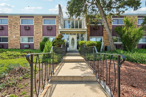 Front view of a two-story brick building with a walkway leading to the entrance.