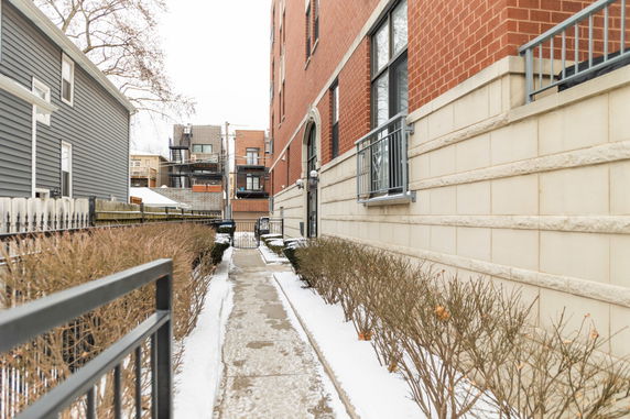 Side view of a brick residential building with a gated entrance.