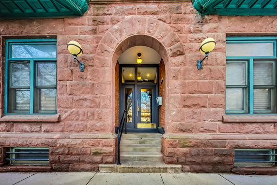 Front view of a building with an arched entrance and stone facade.
