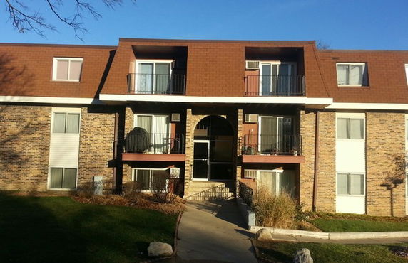 Front view of a multi-story residential building with balconies.