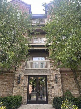 Front view of a multi-story building with balconies and stone facade.