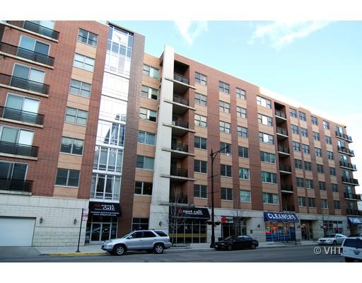 Front view of a multi-story apartment building with street-level shops.