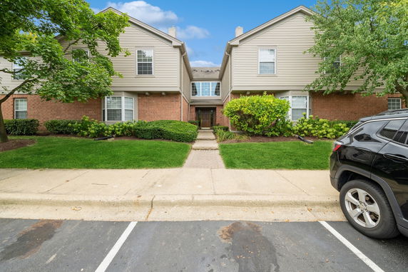 Front view of a two-story residential building with brick and siding exterior.