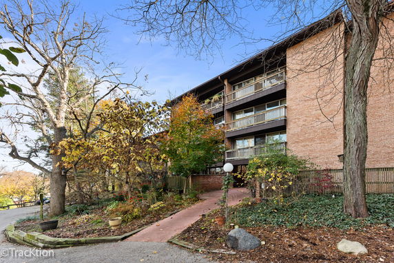 Front view of a multi-story brick apartment building with balconies.