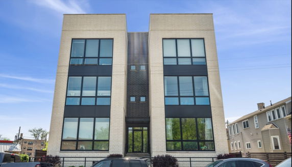 Front view of a modern multi-story building with large windows.