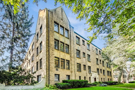 Front view of a multi-story brick building with numerous windows and distinct architectural features.