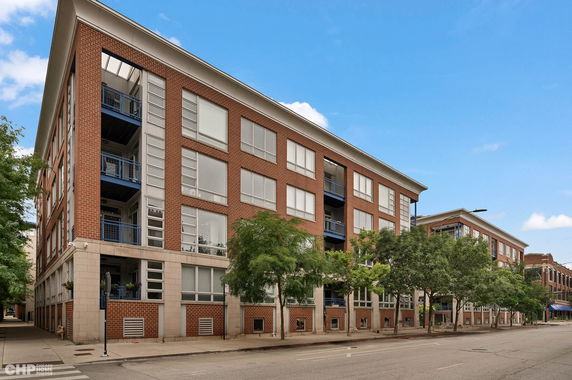 Front view of a multi-story brick apartment building with large windows and balconies.