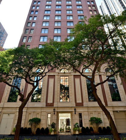 Front view of a multi-story building with a decorative facade and large windows.