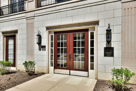 Front view of a building entrance with double doors and decorative lighting.
