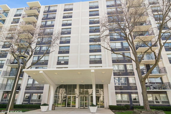 Front view of a multi-story building with balconies and a main entrance.