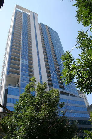 Front view of a modern high-rise building with glass facades and multiple balconies.