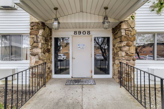 Front entrance of a building with stone accents and a white door.