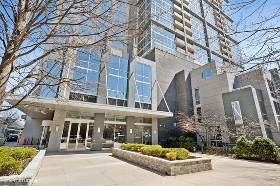 Front view of a modern multi-story building with glass and gray exterior.