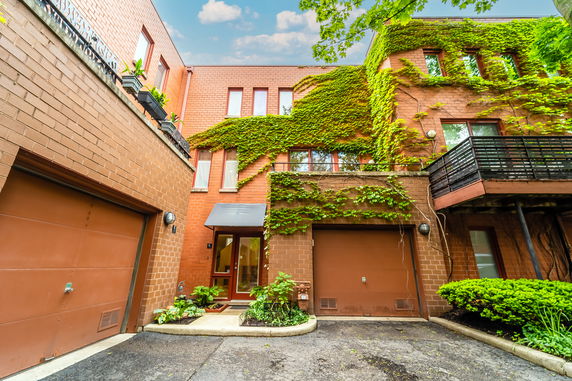 Front view of a multi-story house with ivy-covered walls and a garage.