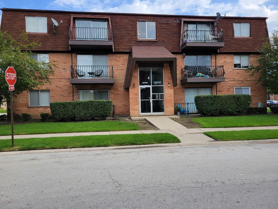 Front view of a three-story apartment building with balconies.