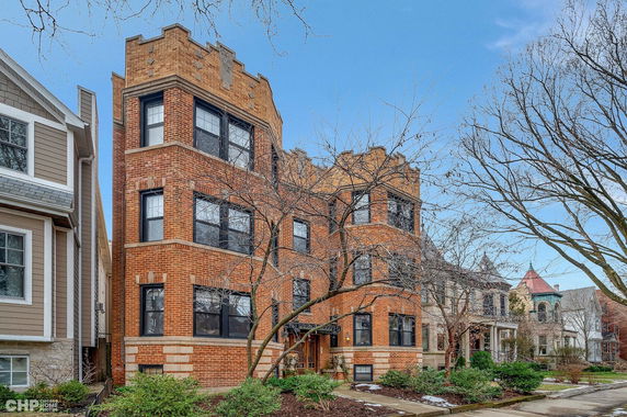 Front view of a three-story brick building with distinct architectural details.