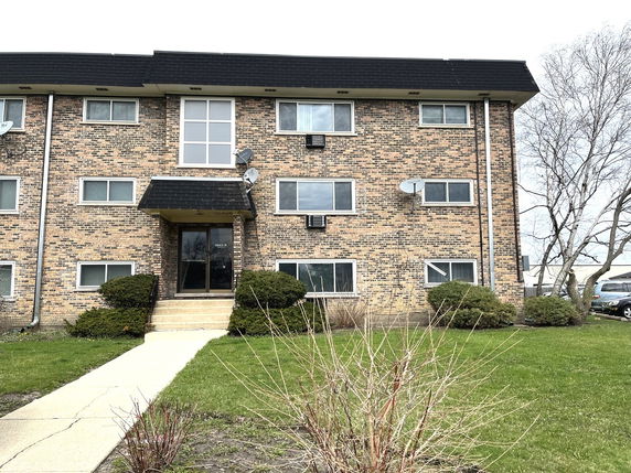 Front view of a multi-story brick apartment building.