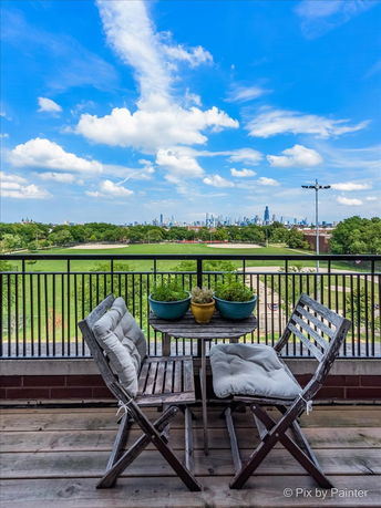 View of surrounding areas seen from a building's balcony showing a city skyline in the distance.