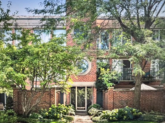 Front view of a two-story brick building with large windows and a circular window feature.