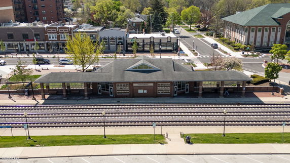 Front view of a train station with tracks and a brick building labeled Westmont.