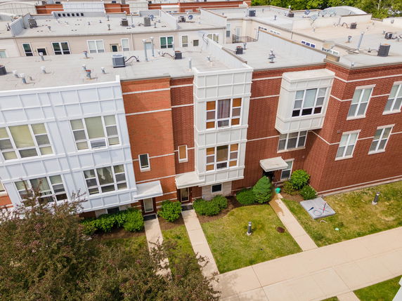 Front view of a brick multi-story building with multiple entrances.