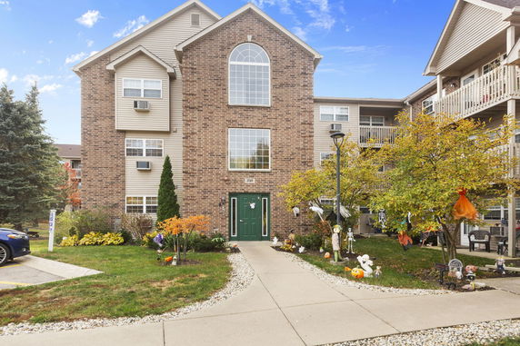 Front view of a multi-story apartment building with brick facade and decorative entrance.