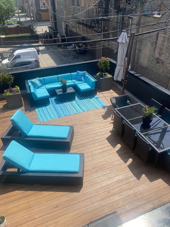 Rooftop with blue seating, lounge chairs, and a dining table.