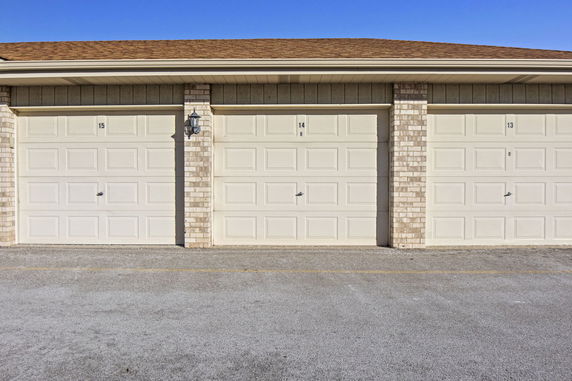 View of a row of garage doors with overhead covers.