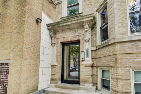 Entrance view of a brick building with decorative molding and a glass door.