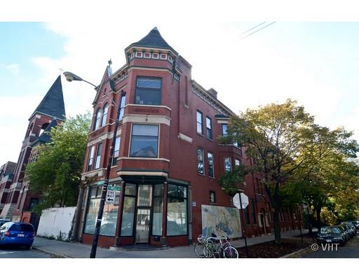 Front view of a multi-story brick building with a corner turret.