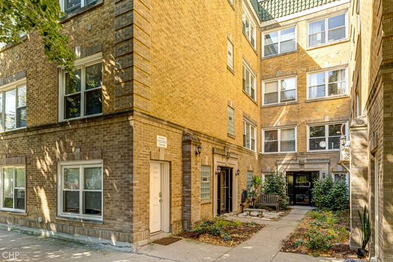 View of a multi-story apartment building with brick exterior and multiple windows.