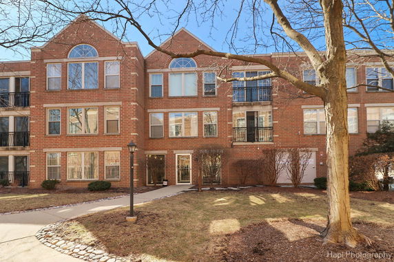 Front view of a multi-story brick building with large windows and balconies.