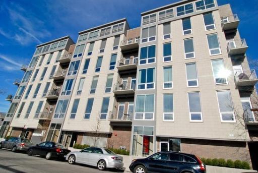 Front view of a multi-story apartment building with balconies.