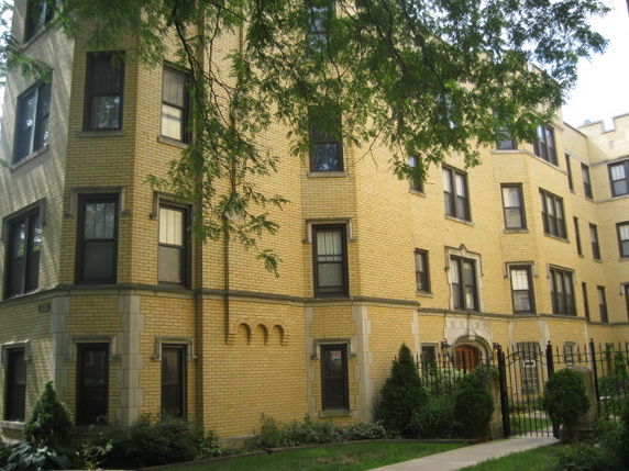 Front view of a multi-story building with yellow brick exterior.