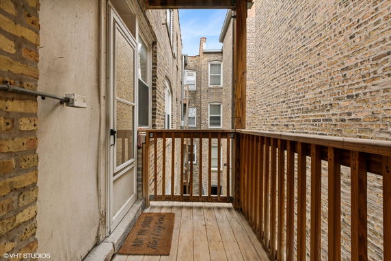 Narrow balcony view between brick buildings.