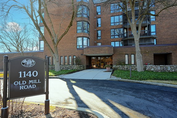 Front view of a multi-story brick building with large windows and a central entrance.