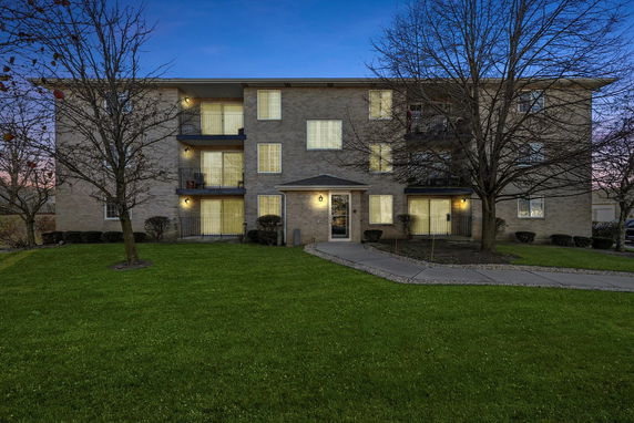 Front view of a three-story apartment building with balconies.