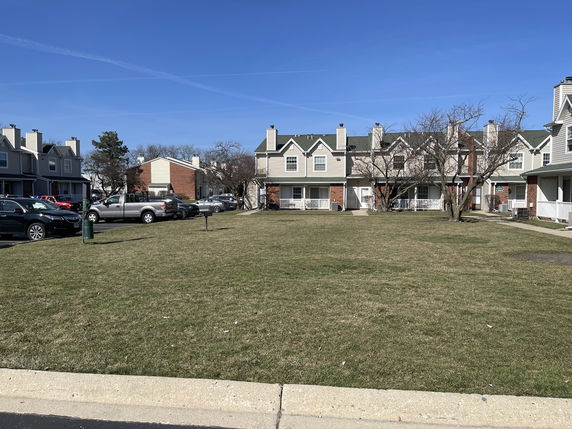 Front view of multiple two-story houses with chimneys and porches.
