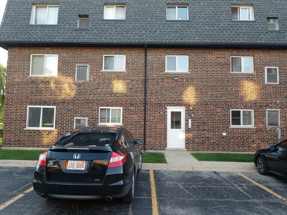 Front view of a three-story brick building with multiple windows.