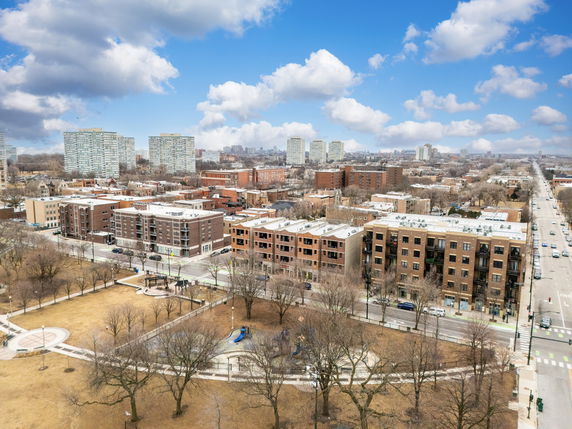 Panoramic city view with multiple apartment buildings and a park.