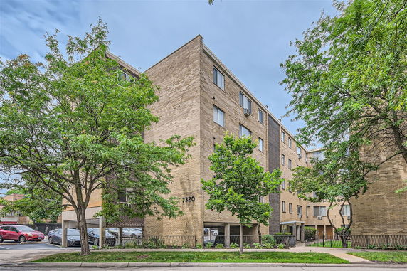 Front view of a multi-story apartment building with brick exterior.