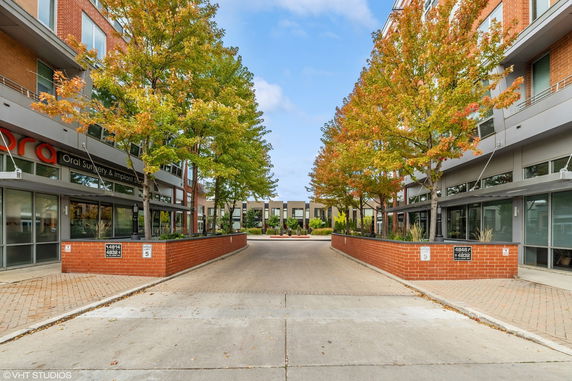 Front view of buildings with a central pathway and autumn trees.